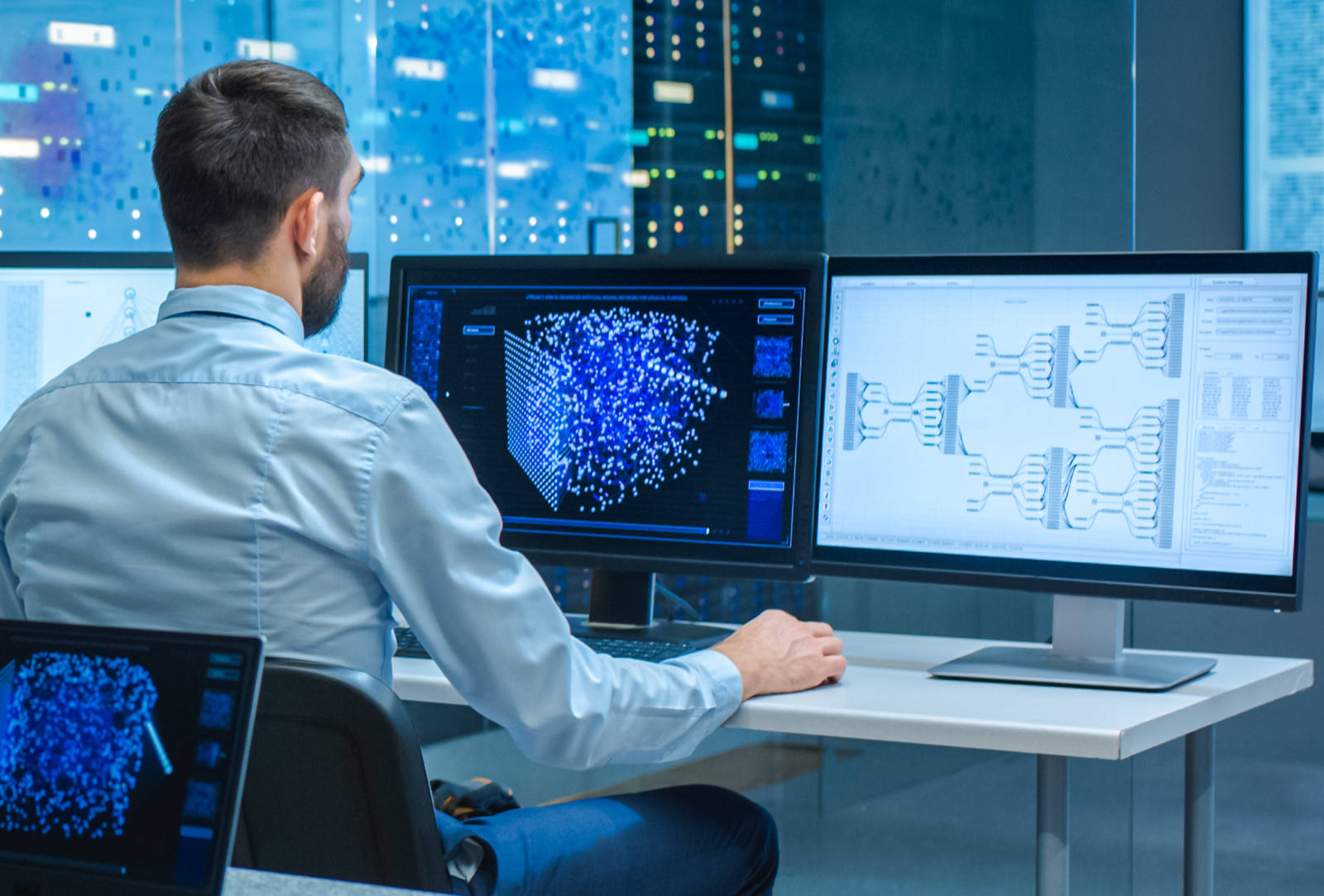 Man on tech computers with three monitors