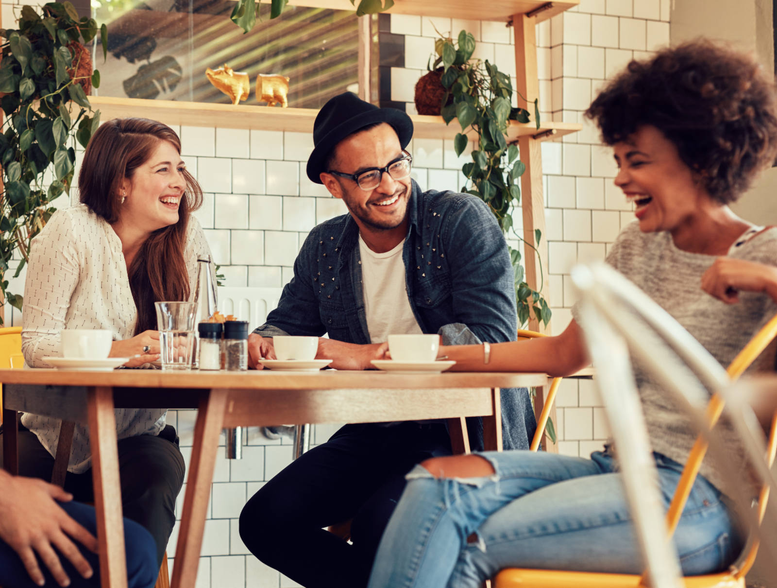 Friends sitting together in coffee shop laughing