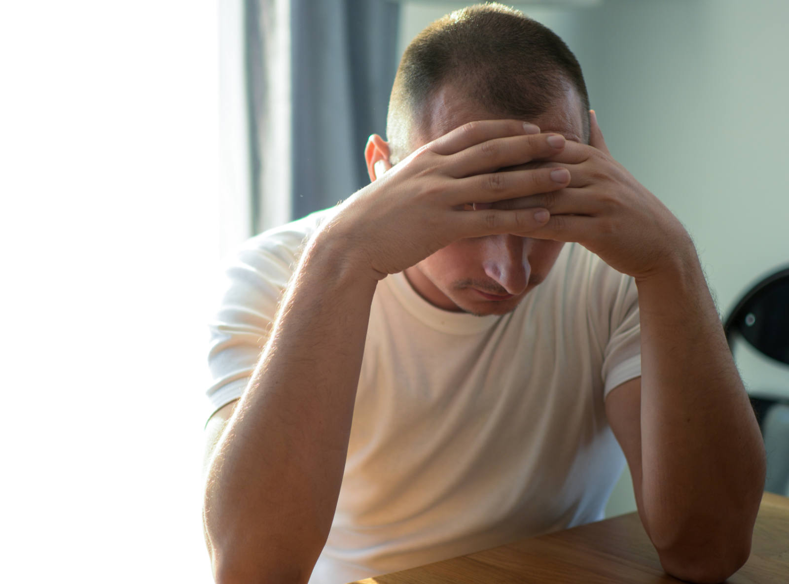 man with hands on forehead