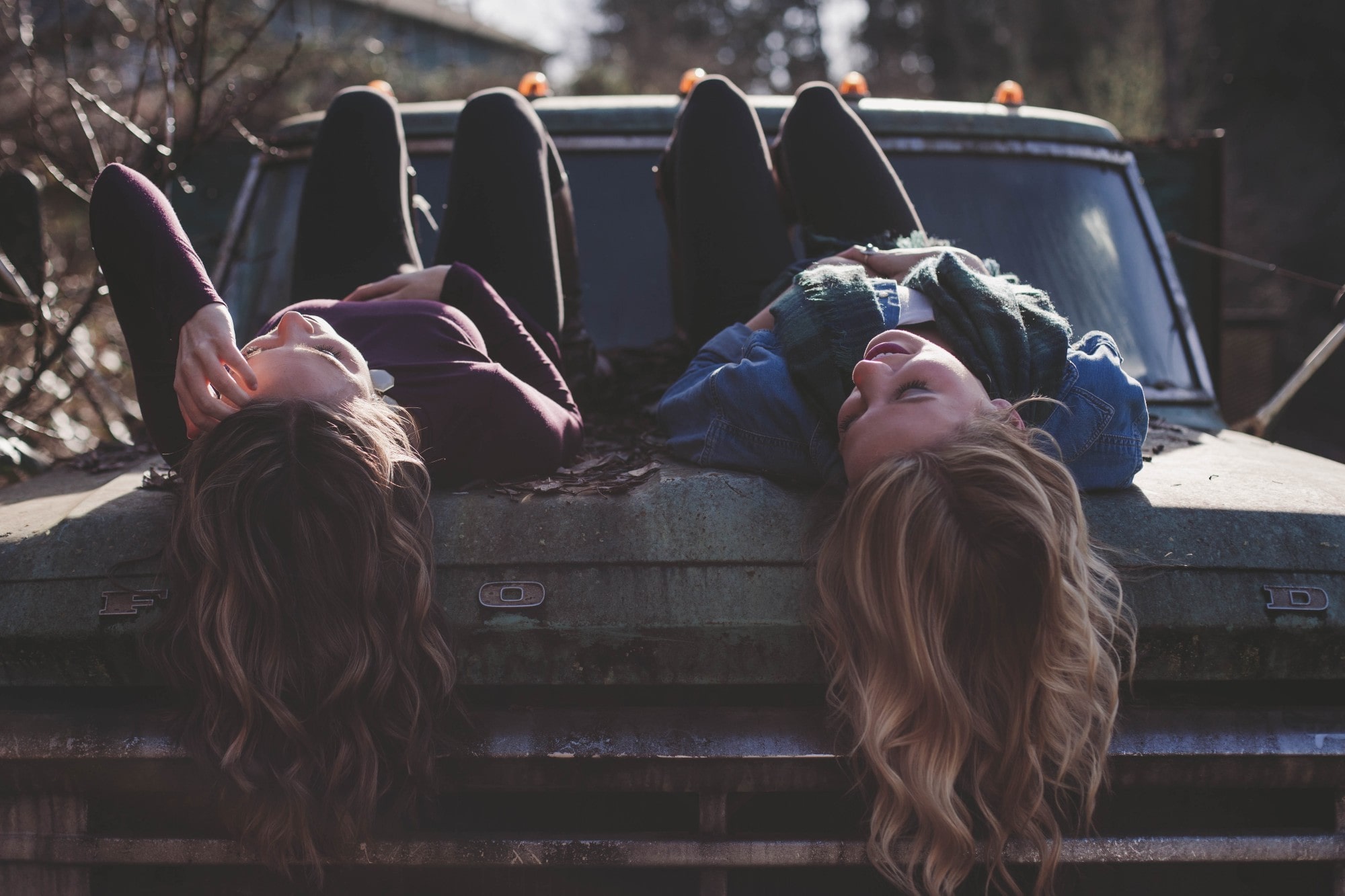 people laying on a car hood