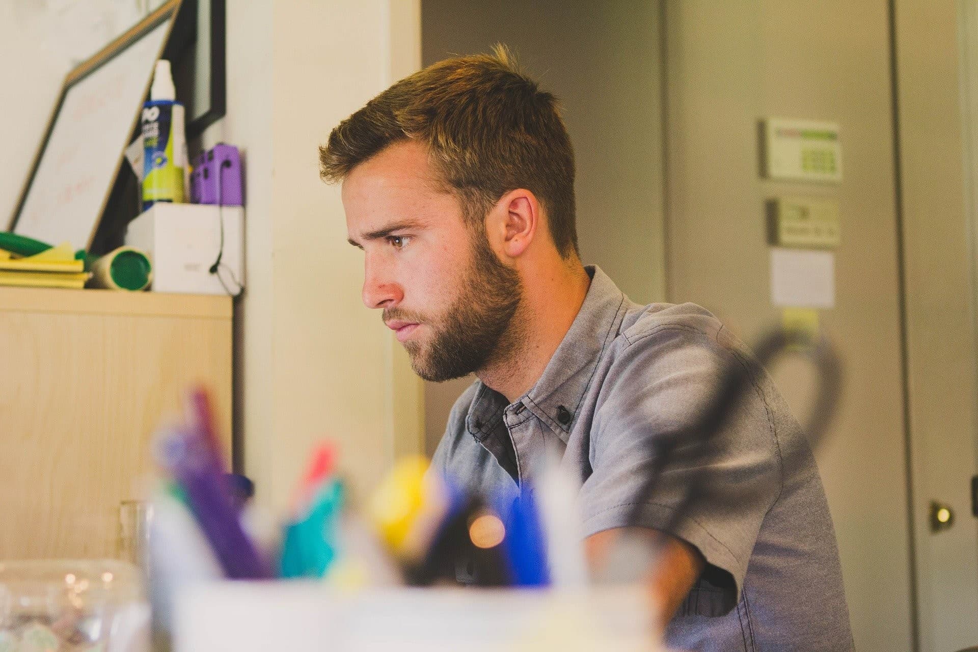 focused man sitting down looking at a computer