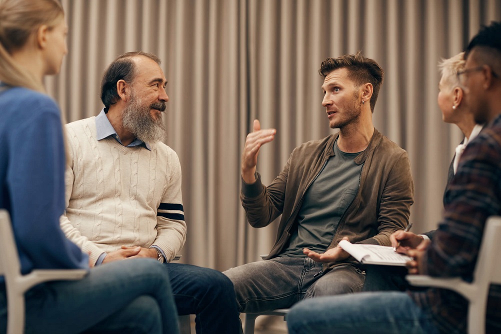 two men sitting down talking to each other