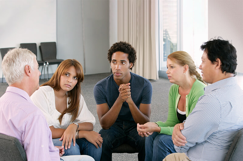 Group therapy session listening to man's story