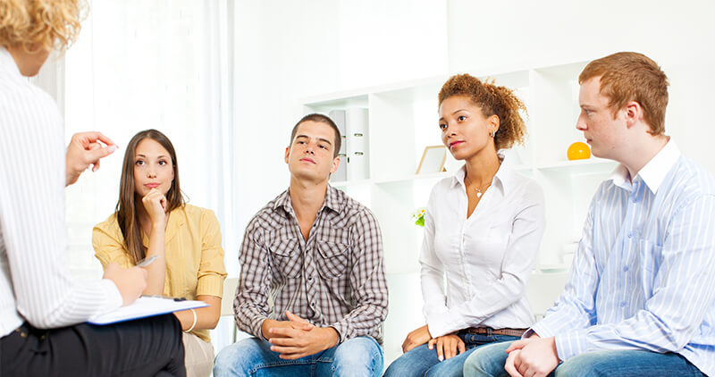 Group of therapy patients listening to therapist