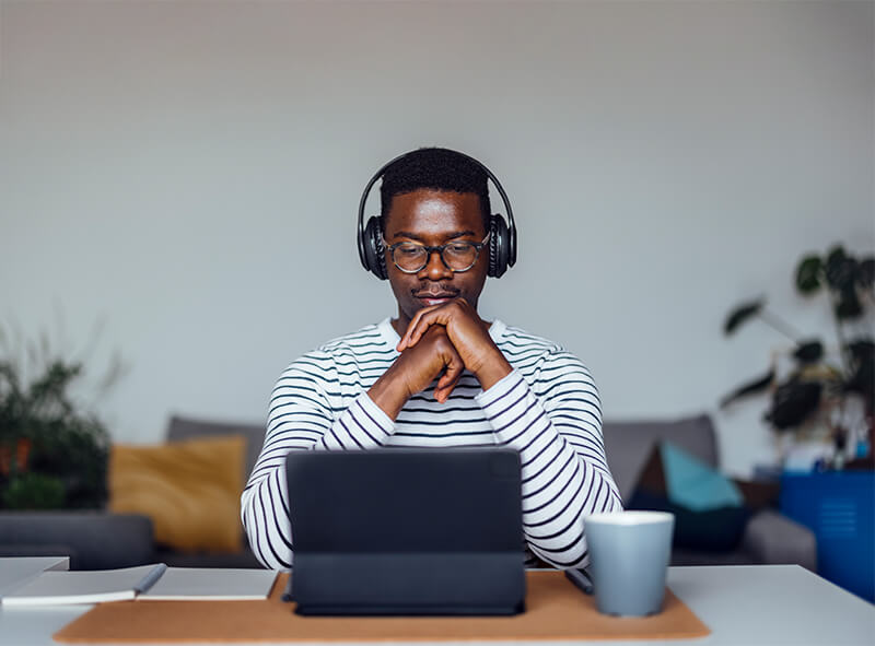 Man wearing headphones and using a laptop