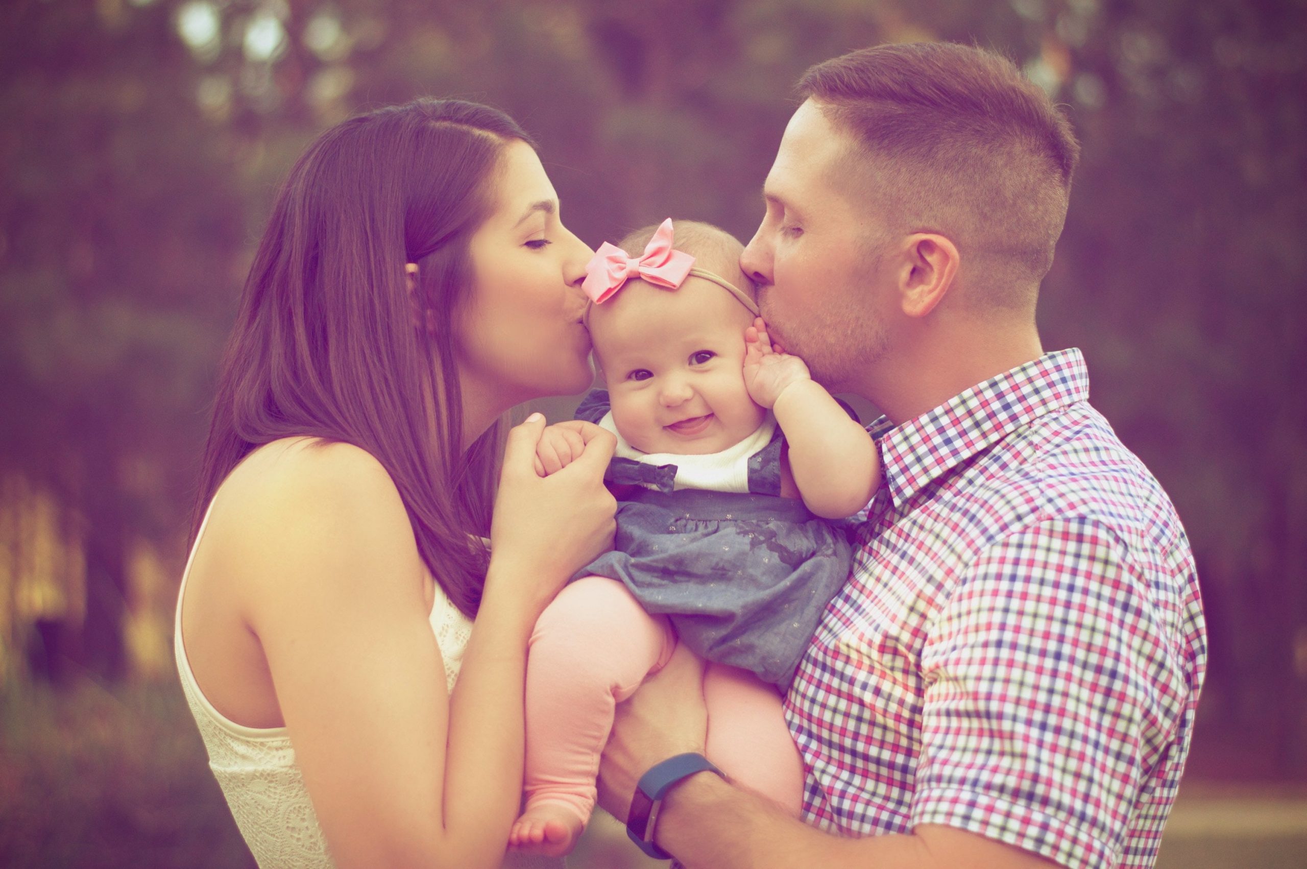 parents kissing baby