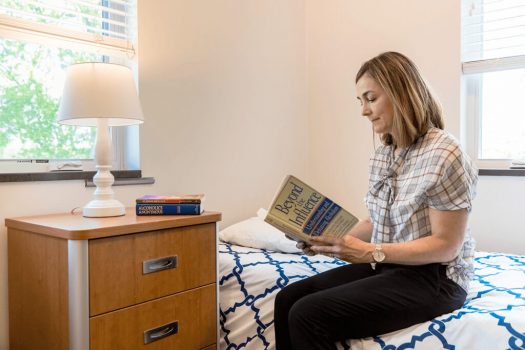 woman sitting in bedroom at Gateway Foundation Lake Villa