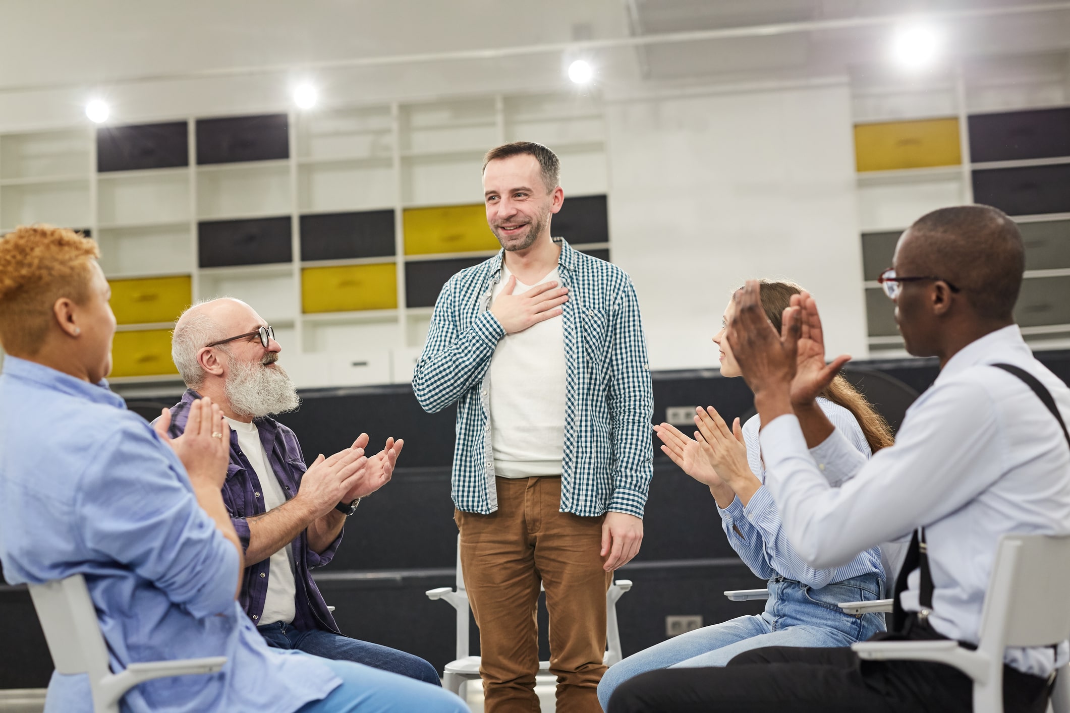 Therapy group applauding man after he told his story
