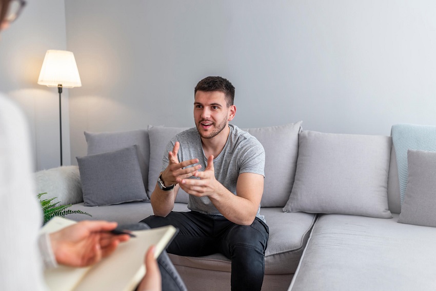 man sitting down on a couch