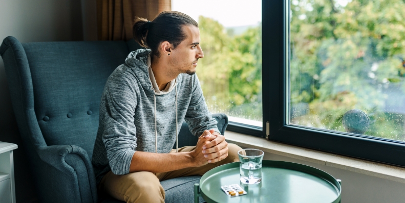 man sitting down looking out window
