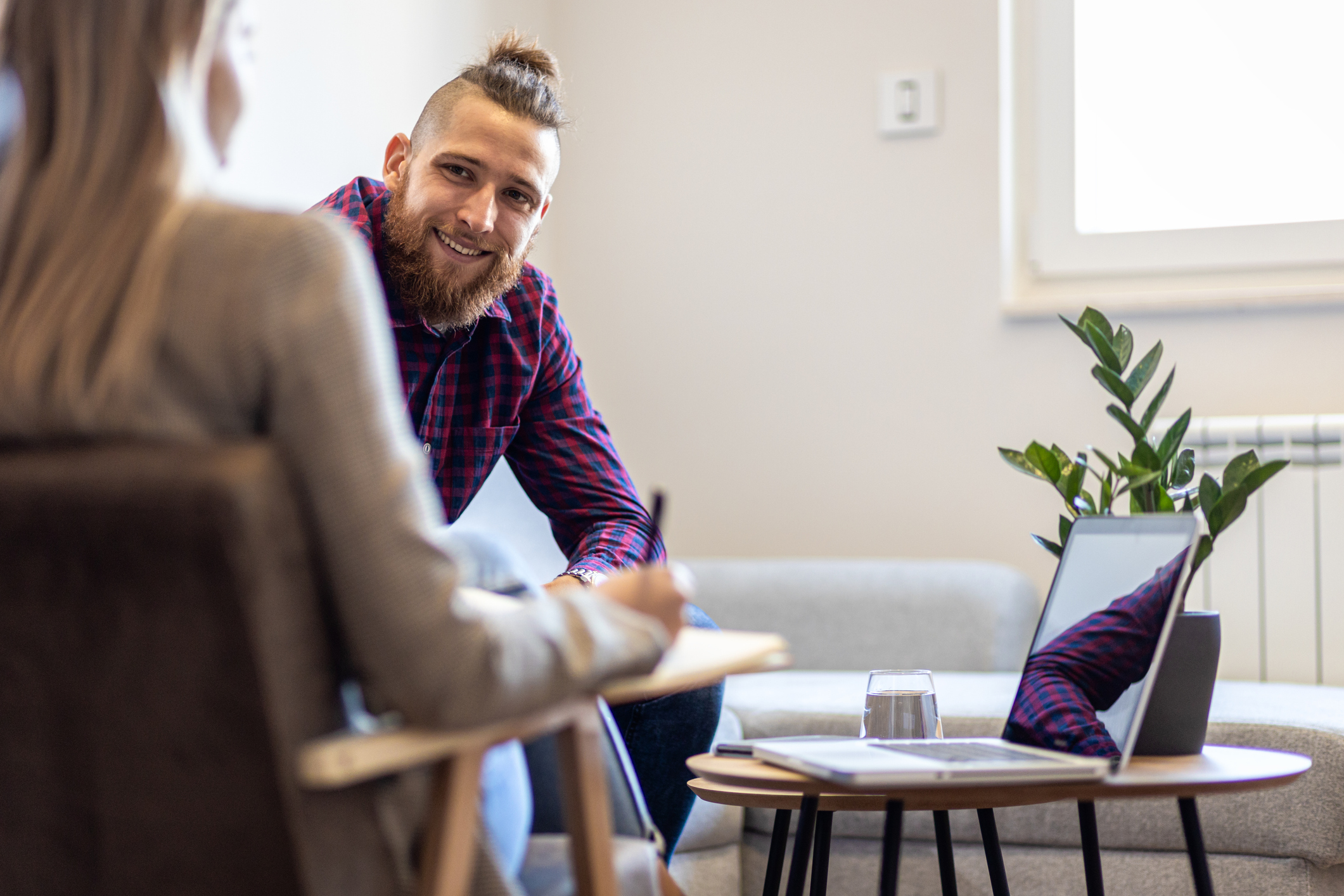 Female psychologist talking to young man during session.