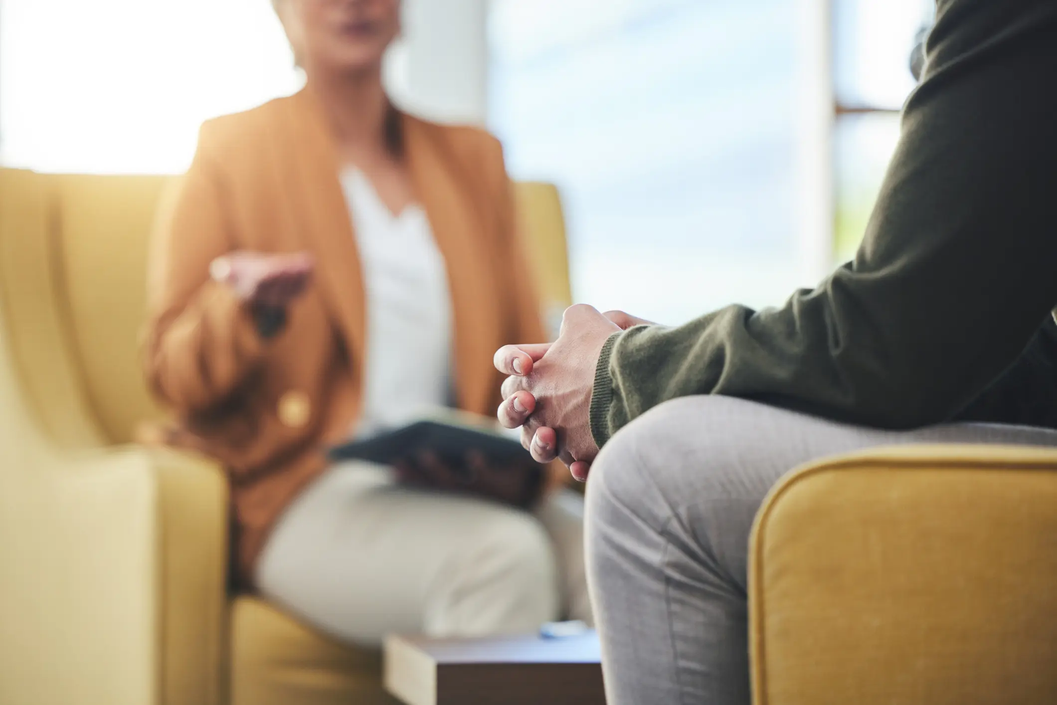 A close up of a patient's hands while talking to a therapist